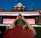  A Buddhist monk holds his hands in the air at the Jokhang temple in Lhasa