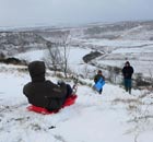 Children play in the snow at the Hole-of-Horcum in the North Yorkshire Moors National Park 
