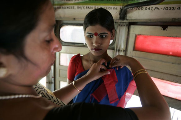 Gallery December 1 2008: Calcutta, India: A volunteer puts a red ribbon on an sex worker