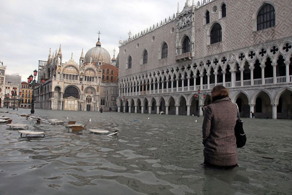 Gallery Flooding in Venice: A woman stands in  flooded St Marks Square