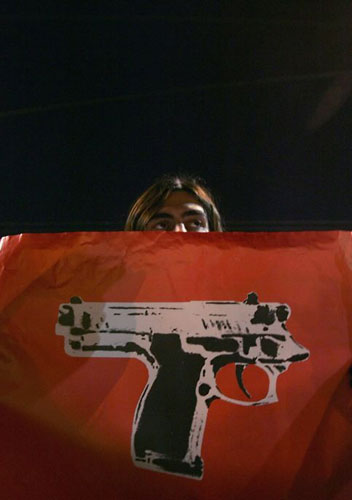 Gallery December 10 2008: Athens, Greece: A youth holds a poster in front of riot police