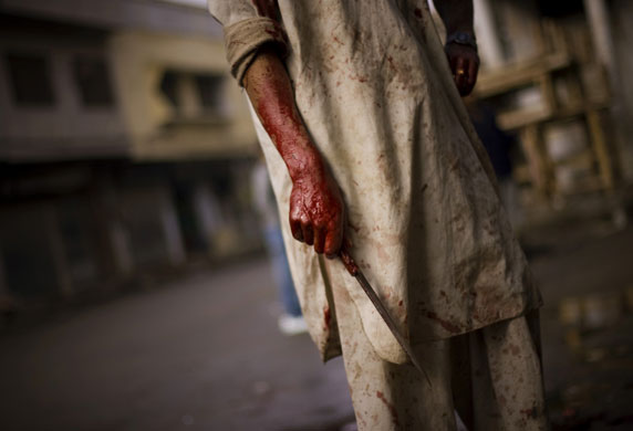 Gallery December 10 2008: Rawalpindi, Pakistan: A butcher holds a knife after slaughtering a cow