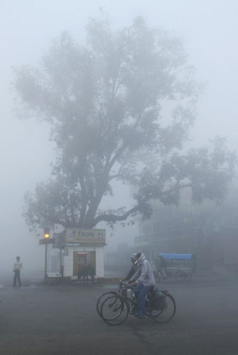 Gallery December 10 2008: Allahabad, India: Two cyclists pedal their way to work in the morning fog