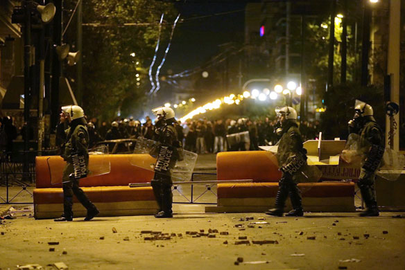 Gallery Greece riots: Riot police walk past a barricade in Athens, Greece