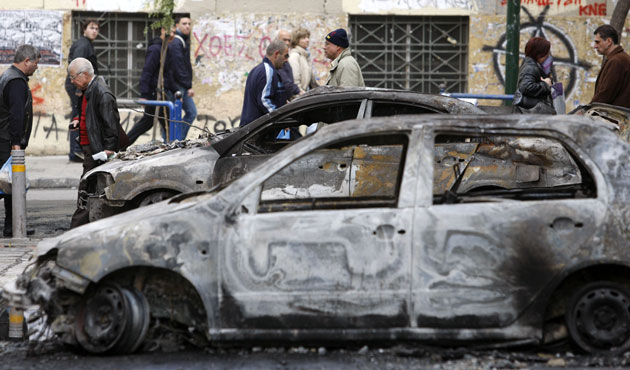 Gallery Greece riots: People walk past burned cars in Athens