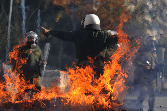 Gallery 24 hours in pictures: A police officer in front of a burning barricade in Thessaloniki 