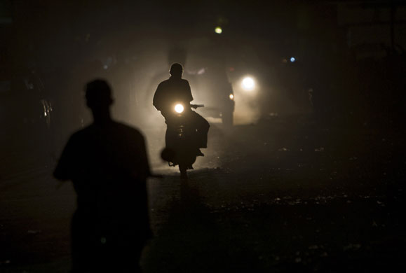 Gallery 24 hours in pictures: A motorcyclist drives at night  in Gonaives , Haiti