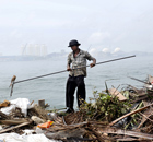 A Bangladeshi migrant worker throws refuse into the lagoon on Thilafushi in the Maldives