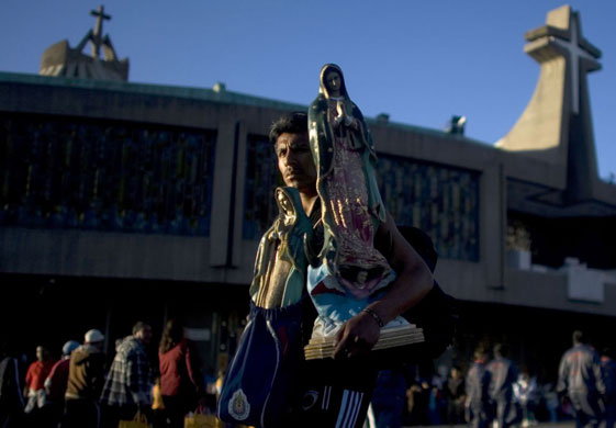 Gallery December 12 2008: Mexico City, Mexico: A pilgrim carries a statue of the Virgin of Guadalupe