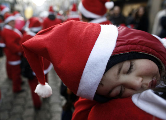 Gallery 24 hours in pictures : Child dressed as Santa Claus sleeps during a parade in the streets of Porto