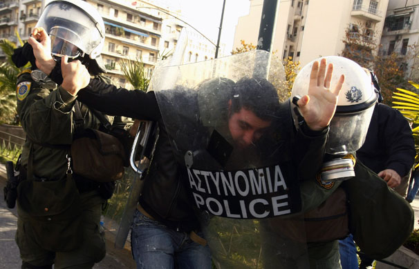 Gallery 24 hours in pictures : Policemen arrest a protester during riots in central Athens
