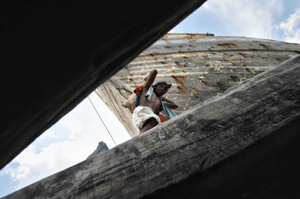 Gallery 17 December 1008: Jakarta, Indonesia: A labourer carries goods into a ship