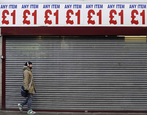 Gallery Business week: A man walks past a discount store in west London