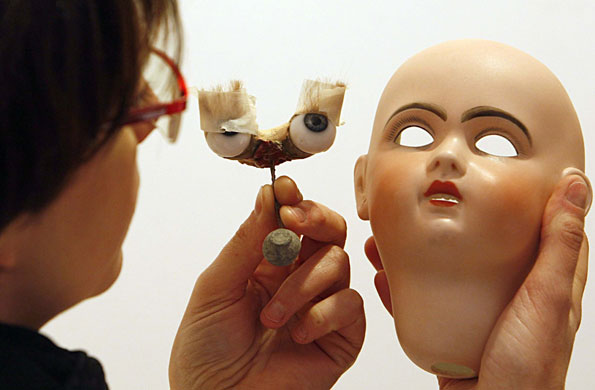 Gallery 24 hours in pictures : Fabienne Mogue holds a broken doll in her workshop in Bordeaux