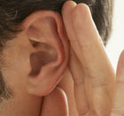 Close-up of man with a hand to his ear
