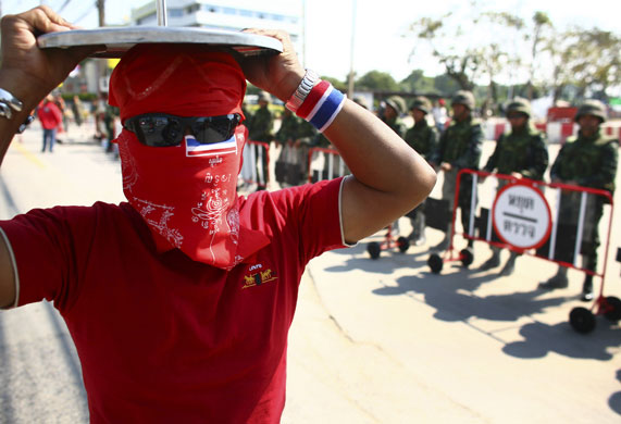 Gallery Thai politics: A pro-government demonstrator walks past Thai soldiers