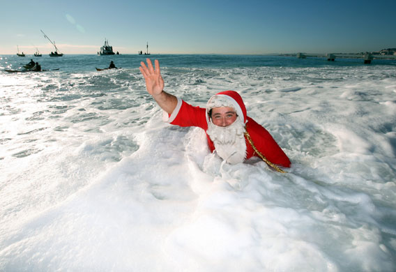 Gallery 24 hours : A man dressed as Santa Claus takes a dip