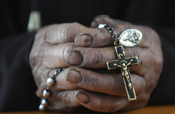 Gallery 24 hours : A faithful holds a cross during a mass at a Catholic church in China