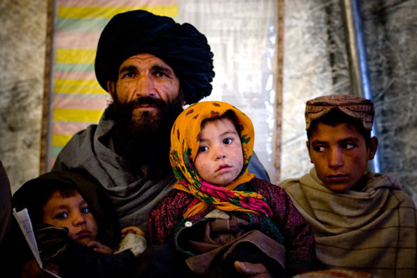 Gallery Life in Lashkar Gah: A man waits for a doctor to examine his child in a clinic in Lashkar Gah