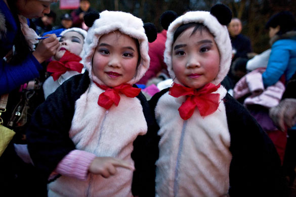 Girls dressed as panda bears get ready to perform during the ceremony marking the delivery of two panda bears from China to Taiwan