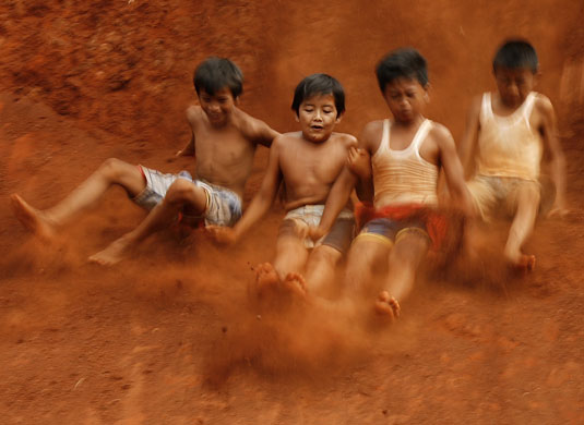 Gallery 24 hours in pictures: Children slide down a slope in Jakarta