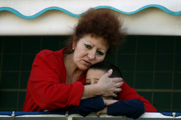 Gallery Ashkelon: Israeli woman hugs boy at scene of rocket attack