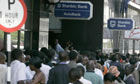 People line up to withdraw cash from local banks in Harare