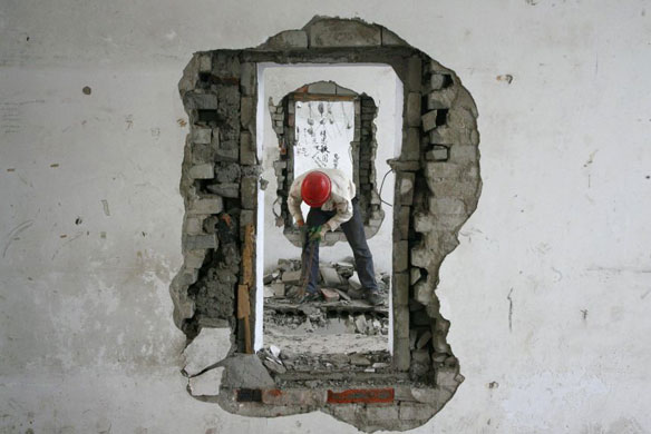 Gallery December 3 2008: Suining, China: A migrant labourer demolishes an old apartment building