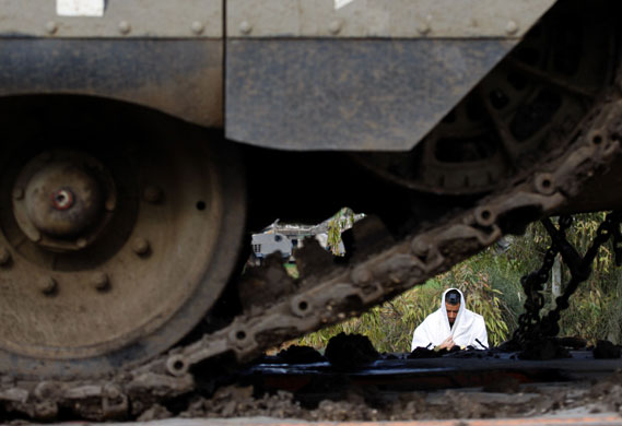 Gallery 30 December 2008: Gaza Strip: An Israeli soldier prays near armoured vehicles