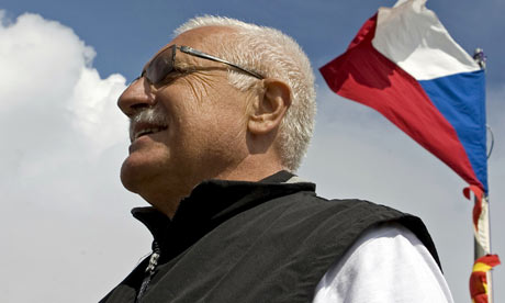 A Czech flag waves behind Czech President Vaclav Klaus as he stands on Snezka mountain