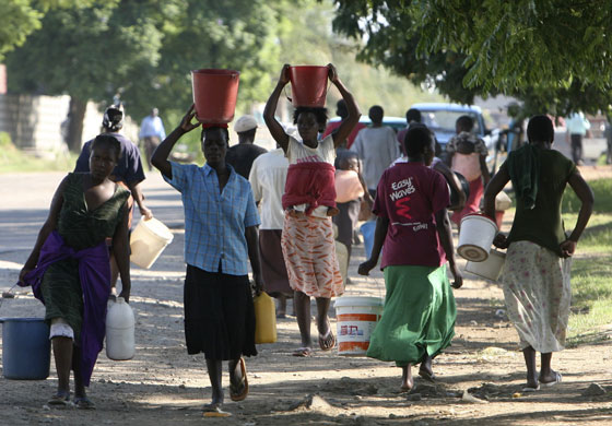 Gallery Zimbabwe cholera: Women carry water in buckets in Harare