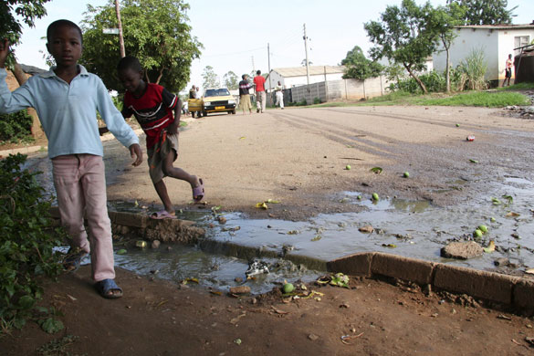 Gallery Zimbabwe cholera: Children walk past sewage water in Glen View, Harare