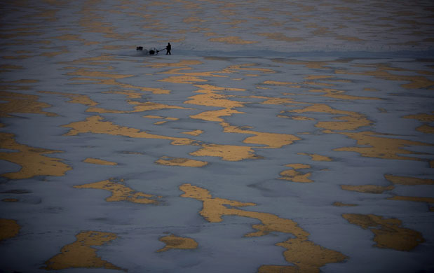 Gallery 24 hours in pictures: Men cut ice blocks off the frozen Songhua river 