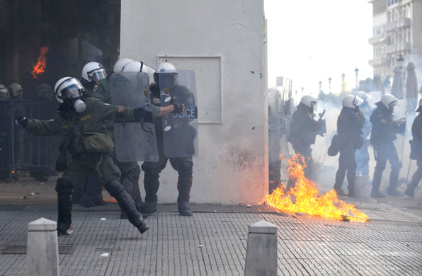 Gallery Riots in Athens: A petrol bomb burns next to riot police during trouble in Thessaloniki