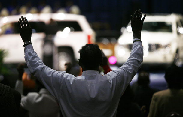 Gallery 24 hours in pictures: A man prays for the future of the US auto industry during a special service