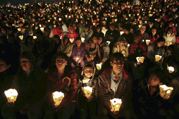 Gallery 24 hours in pictures: People hold candles  during a Christmas light ceremony in Bogota