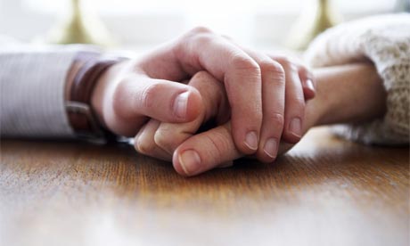 couple holding hands in rain. A couple holding hands.