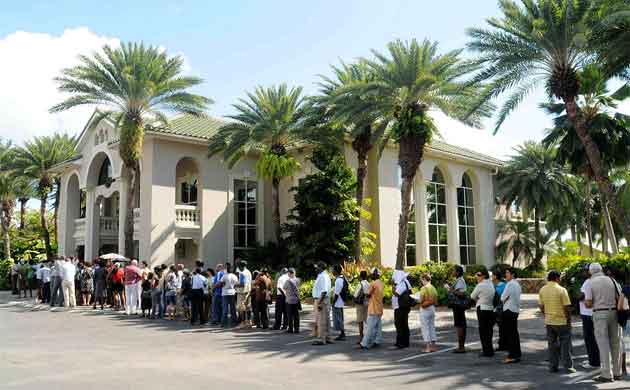 People seeking to withdraw funds line up outside the Bank of Antigua in Collage 