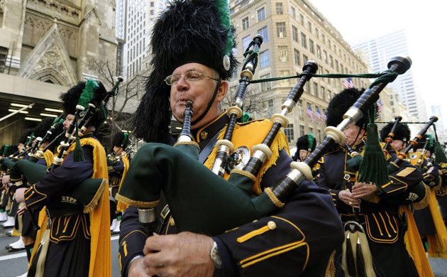 Members of the Bergen county police pipe and drum band pass by St Patrick's cathedral in New  York