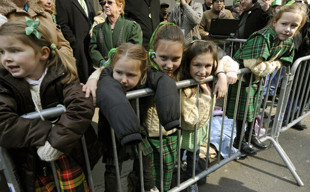 Girls watch marching bands during the St Patrick's Day parade in New York 