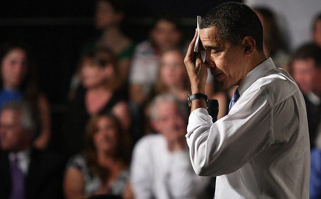 Barack Obama wipes his brow during a town hall meeting
