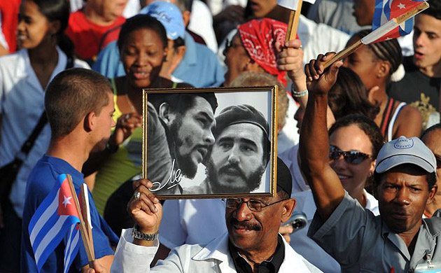 A man holds a photo of Fidel Castro and Ernesto 