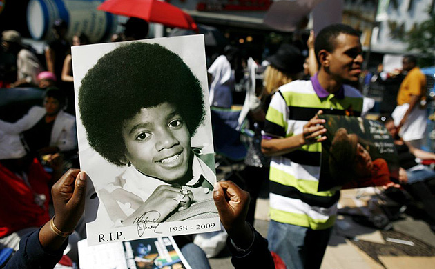A fan holds an autographed photo of Michael Jackson at the Apollo theatre in New York. 