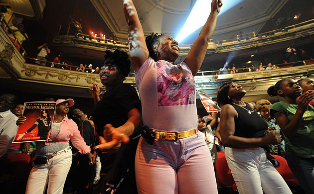 The crowd at Harlem's Apollo theatre dances during a tribute to Michael Jackson