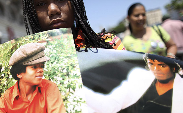  Taveon Aiken holds up two Michael Jackson posters outside the theatre