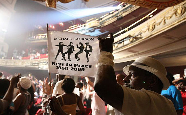 A man holds a flag commemorating Michael Jackson