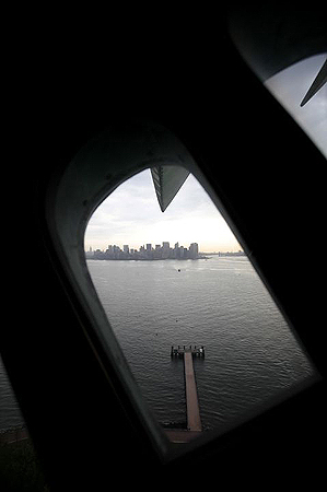 The Manhattan skyline is seen from the crown of the The Statue of Liberty.