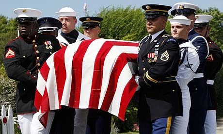 Members of the US military honour guard carry a casket containing the body of Edward Kennedy outside of the Kennedy compound