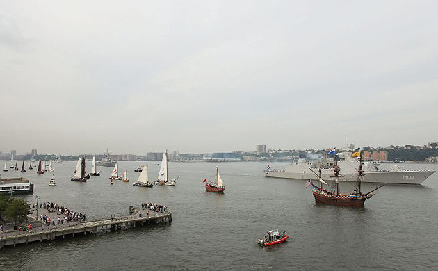 A flotilla of 11 ships including Dutch naval frigates, Nato vessels, Dutch barges, and a replica of Henry Hudson's Half Moon sail past the USS Intrepid 
