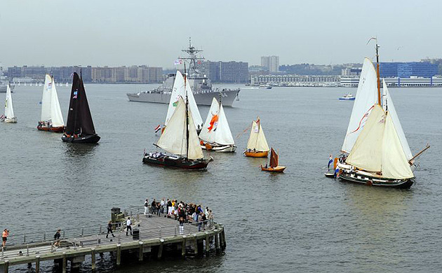 A flotilla of ships make its way up the Hudson River 